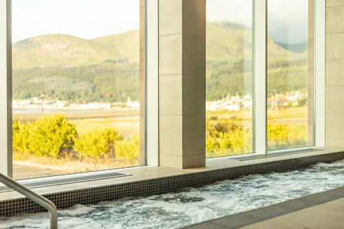a jacuzzi tub in a building with windows at Slieve Donard in Newcastle