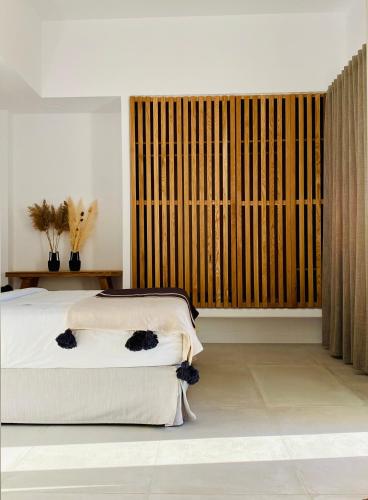 a bedroom with two beds and a large window at Adama Mykonos Boutique Hotel in Mýkonos City