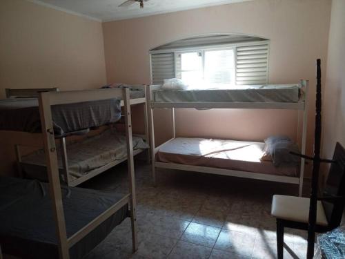 um quarto com 3 beliches e uma janela em casa c/4 dormitórios e piscina em Botucatu