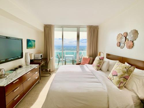 Pokój hotelowy z dużym łóżkiem i telewizorem w obiekcie Balcony Ocean View ! Pool - WiFi - Gym - Parking w Miami