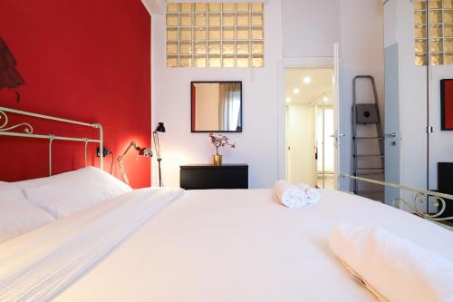 1 dormitorio con cama blanca y pared roja en PrimoPiano - Palmaria, en Milán