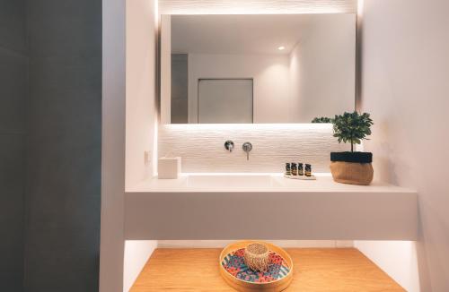 a bathroom with a sink and a mirror at Adama Mykonos Boutique Hotel in Mýkonos City