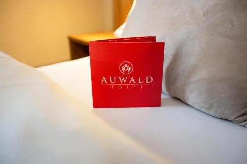 a red book sitting on top of a bed at Auwald Hotel in Ingolstadt