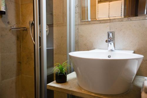 a bathroom with a white sink and a shower at Auwald Hotel in Ingolstadt