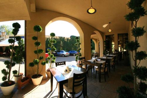 a restaurant with tables and chairs and potted plants at Pension Passion in Târgu-Mureş
