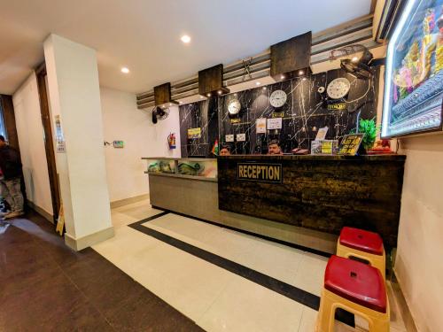 a restaurant with a counter and a red stool at HOTEL SUN CITY in Puri