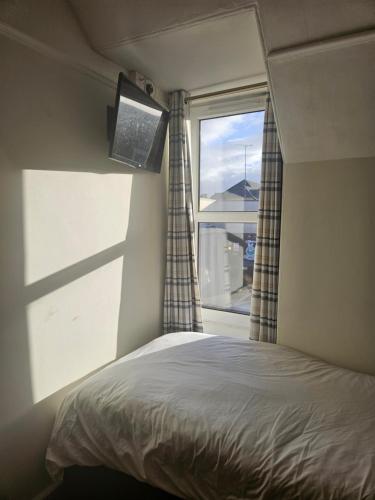 a bedroom with a bed and a window at Dunskaith Villa in Inverness