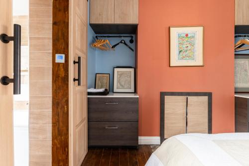 a bedroom with an orange wall and a dresser at Prime Location, 5* Marylebone: Central London Gem in London