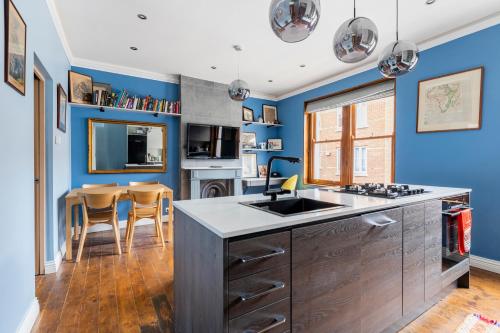 uma cozinha com paredes azuis e um balcão em Prime Location, 5* Marylebone: Central London Gem em Londres
