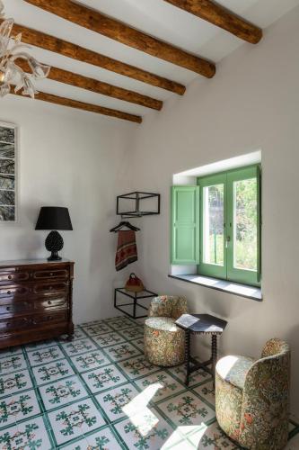 a living room with two chairs and a window at Frangimare - La Malandrina in Malfa