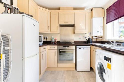 a kitchen with a white refrigerator and a dishwasher at Modern 3 bedroom home *EVcharging* Garden, Parking in Darlington