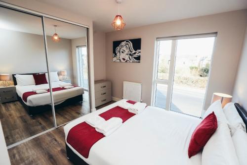 a bedroom with two beds and a mirror at The Stay Company, Devonshire Court in Nottingham