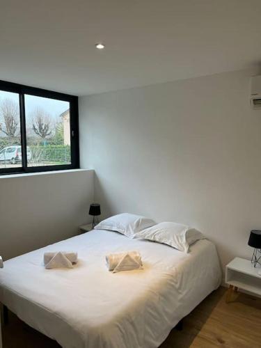 ein weißes Bett in einem Zimmer mit Fenster in der Unterkunft La Maison Majolane, calme & Cosy - 100m du Tram in Meyzieu