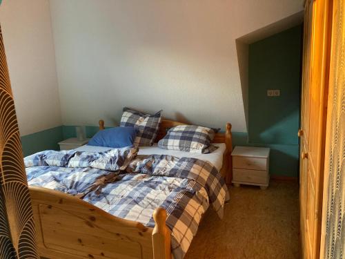 a bedroom with a bed with plaid sheets and pillows at Pyramide Haus 51,8 in Bad Nenndorf