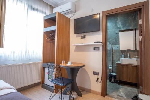 ein Bad mit einem Waschbecken und einem Tisch in einem Zimmer in der Unterkunft Campus Butik Hotel in Avcılar