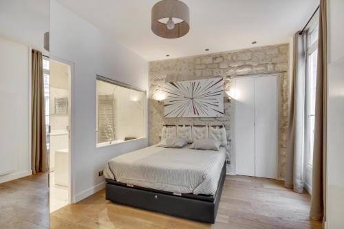 een slaapkamer met een bed en een stenen muur bij mandar 14 in Parijs