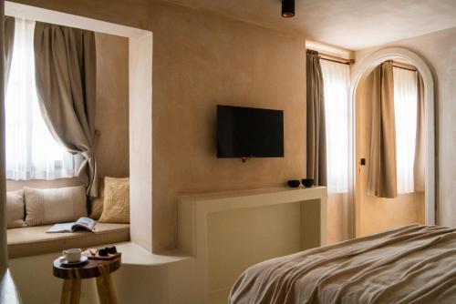 ein Schlafzimmer mit einem Bett und einem TV an der Wand in der Unterkunft Noi Hotel Bodrum in Bodrum City