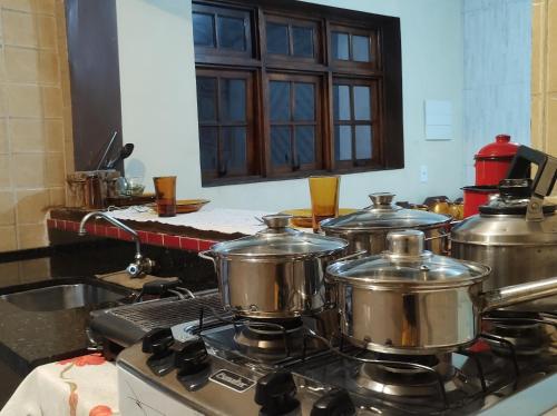 a group of pots on a stove in a kitchen at Hospedagem San Gonzales Two in Sorocaba