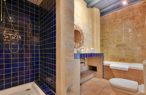 La salle de bains est pourvue de toilettes et d'une baignoire. dans l'établissement Les suites de charme du Portalet, à Uzès