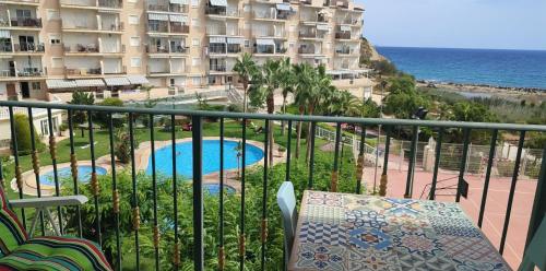 einen Balkon mit Blick auf den Pool und ein Gebäude in der Unterkunft Beachfront Merced apartman in El Campello