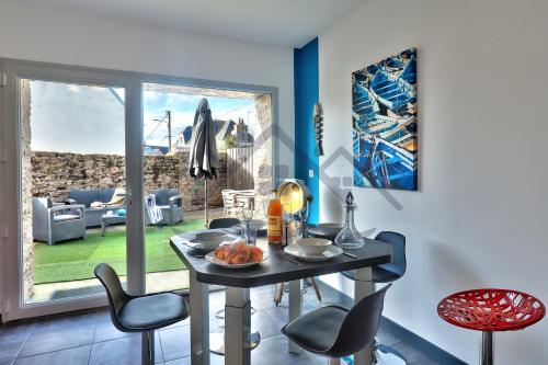 d'une salle à manger avec une table, des chaises et une fenêtre. dans l'établissement LocaLise - M2A - La maison bleue avec extérieur entièrement clos - Proche du centre et du port - Draps inclus - Animaux bienvenus, au Guilvinec