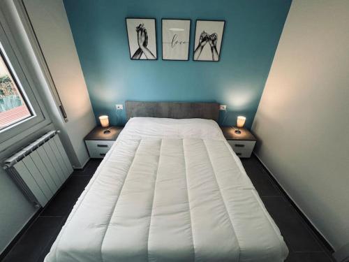 - un lit dans une chambre avec 3 photos sur le mur dans l'établissement Casa Victoria A due passi dall'Ariston Internet Gratis, à Sanremo