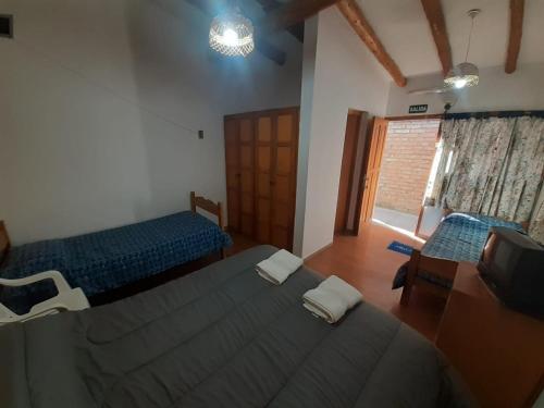 a bedroom with two beds and a television in it at Abi in Esquel