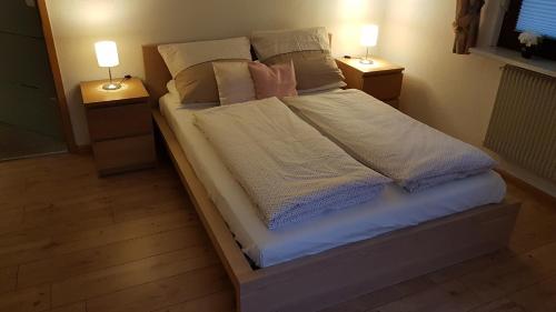 1 dormitorio con 1 cama con almohadas y 2 lámparas en Ferienwohnung Bohnert-Arias en Bad Peterstal-Griesbach