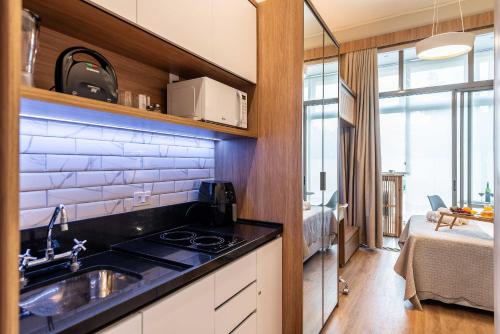 a kitchen with a sink and a kitchen with a bed at ARQ VILA MARIANA in Sao Paulo