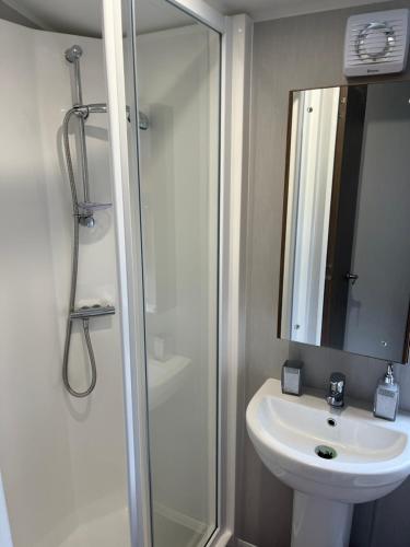 a bathroom with a shower and a sink and a mirror at BlackJak Retreat in Grange Over Sands