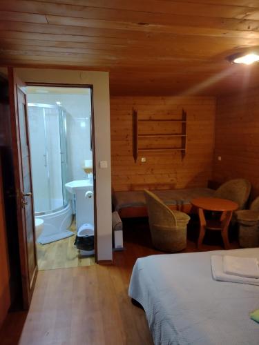 1 dormitorio con 1 cama, lavamanos y mesa en Agroturystyka U BOŻENY en Przysłup