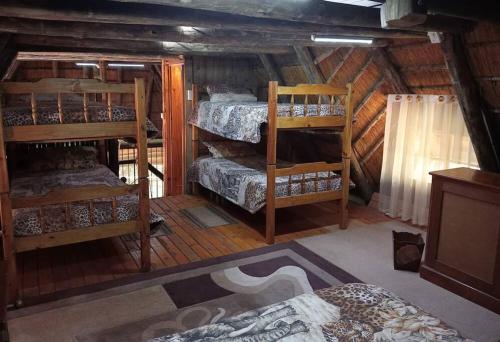 a room with four bunk beds in a cabin at Hedgehog Cabin in Marloth Park