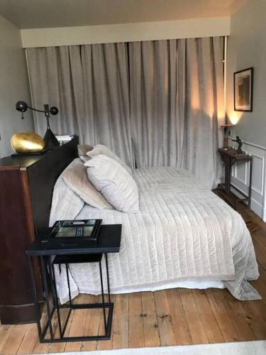- une chambre avec un lit et une table avec une table de chevet dans l'établissement Sublime appartement Bordeaux Hôtel de Ville, à Bordeaux