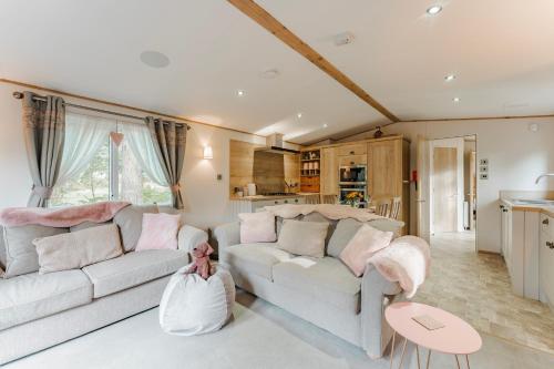 a living room with a couch and a table at The Pines - Norfolk Cottage Agency in Weybourne