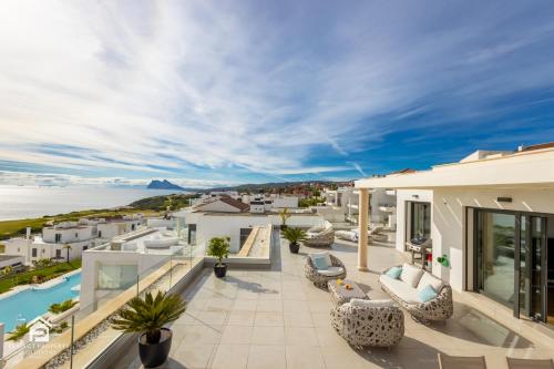 uma casa com uma varanda com vista para o oceano em Luxury penthouse with huge terrace and sea and golf views em San Roque