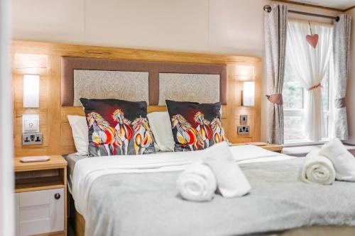 a bedroom with a large bed with towels on it at The Pines - Norfolk Cottage Agency in Weybourne
