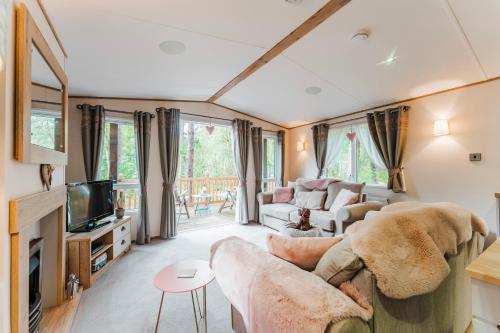 a living room with a couch and a tv at The Pines - Norfolk Cottage Agency in Weybourne