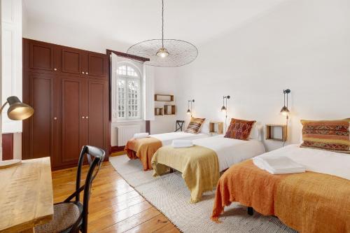 una camera da letto con due letti, un tavolo e delle sedie di Quinta do Coração de Jesus a Sintra