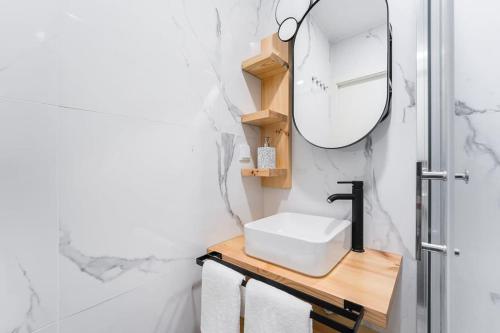 W łazience znajduje się umywalka i lustro. w obiekcie A charming stay near Paço das Escolas w mieście Coimbra