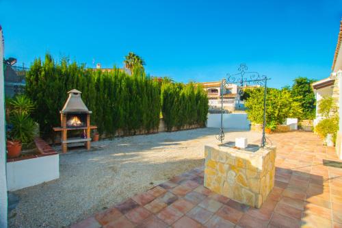 a patio with a fireplace and a fire pit at Villa Garlanda - PlusHolidays in Benissa