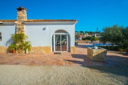 a white house with a brick patio and a brick pillar at Villa Garlanda - PlusHolidays in Benissa