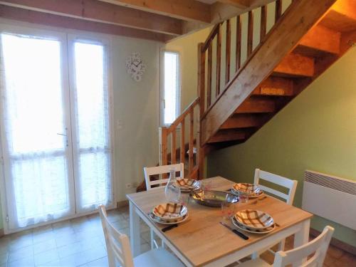 une salle à manger avec une table et un escalier dans l'établissement Meschers sur Gironde - VILLA avec TERRASSE - IDEAL vacances en famille, à Meschers-sur-Gironde