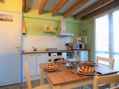 - une cuisine avec une table en bois et des bols dans l'établissement Meschers sur Gironde - VILLA avec TERRASSE - IDEAL vacances en famille, à Meschers-sur-Gironde