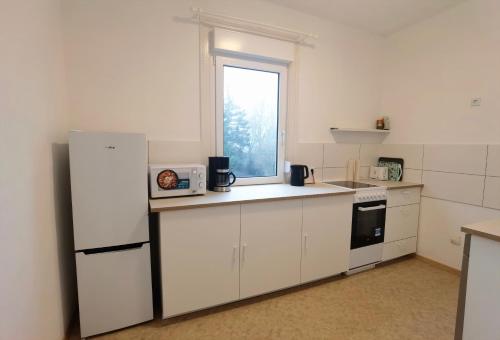 a kitchen with white cabinets and a window at Bad Homburg Wohnung in Bad Homburg vor der Höhe