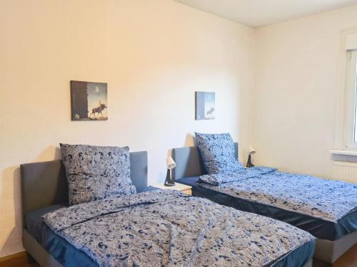 two beds in a bedroom with blue comforters at Bad Homburg Wohnung in Bad Homburg vor der Höhe