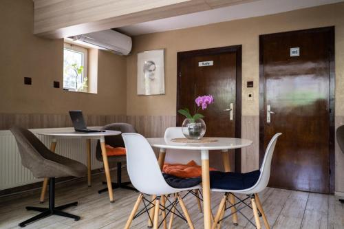 ein Esszimmer mit einem Tisch, Stühlen und einem Laptop in der Unterkunft Jeweller Hotel in Ruse