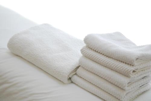 a stack of white towels sitting on top of a bed at Samseong,Coexmall A in Seoul