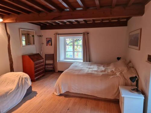 a bedroom with a large bed and a window at La maison d'à côté in Tellin
