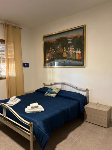 Un dormitorio con una cama azul con una pintura en la pared en B&B Casa Vacanze Stella Di Mare, en Battipaglia