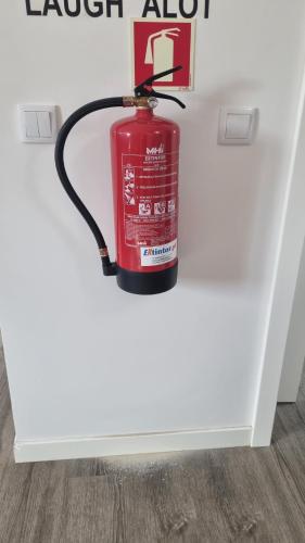 a fire extinguisher hanging from a wall at Katyto house in Costa da Caparica